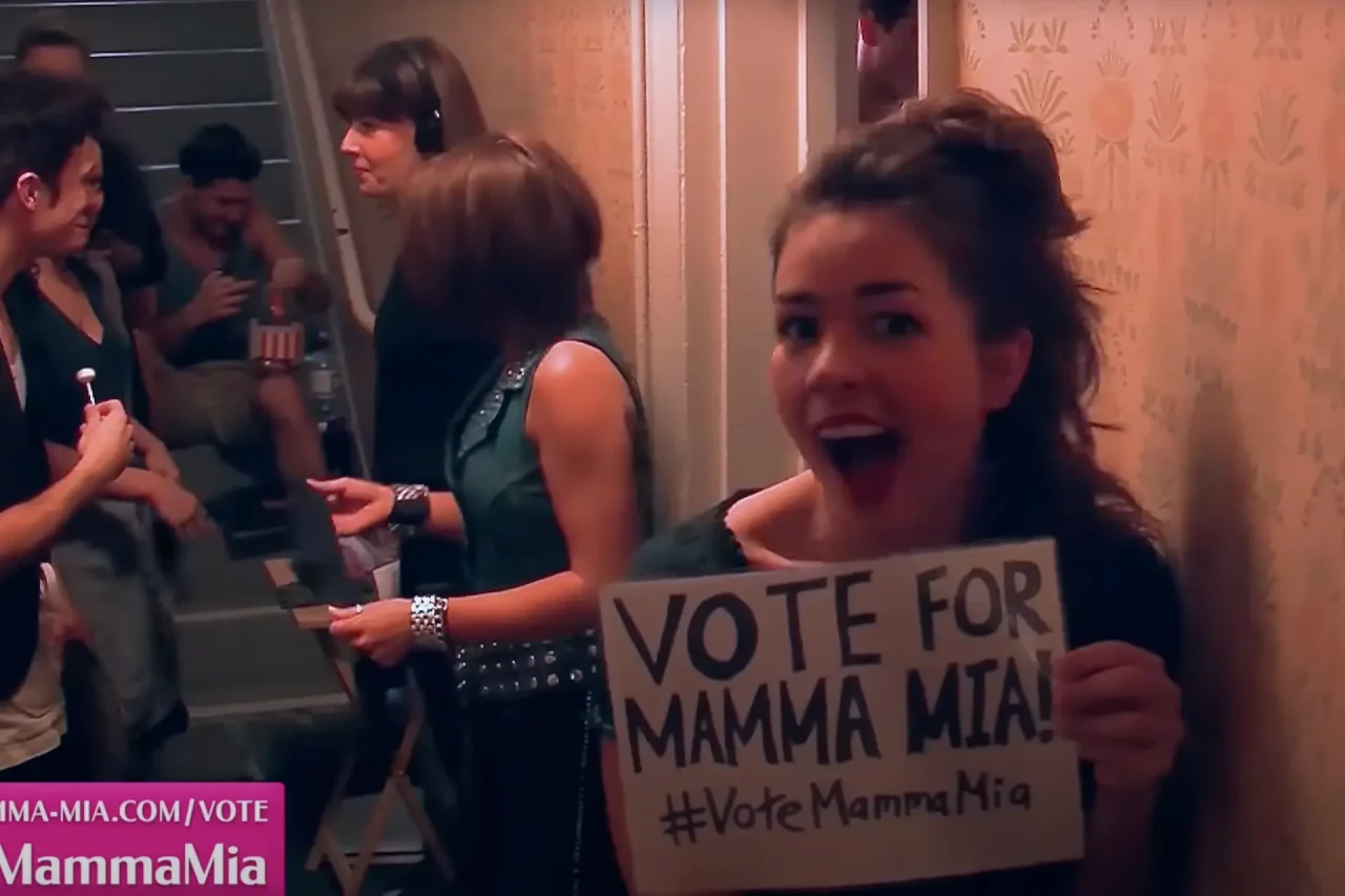 MAMMA MIA! cast hold up a poster with Vote for MAMMA MIA! in the This Morning Audience Award at the Oliviers 2015
